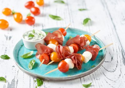 Spiedini di bresaola, mozzarelline e ciliegini bicolor con crema di basilico senza aglio e formaggio cremoso